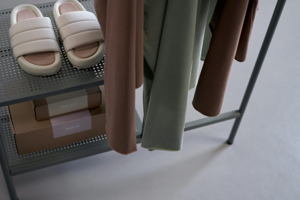 A minimalist display featuring casual clothing, slippers, and packaging indoors.